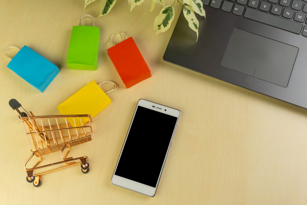 Ecommerce shopping cart with phone and laptop on desk representing checkout abandonment
